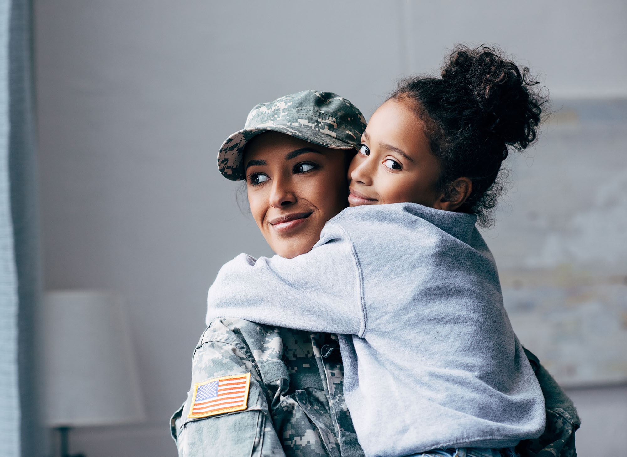 Army woman hugging girl